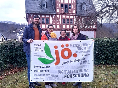 Vier JÖ West Vorstände stehen mit der JÖ Fahne vor einem Haus im Garten