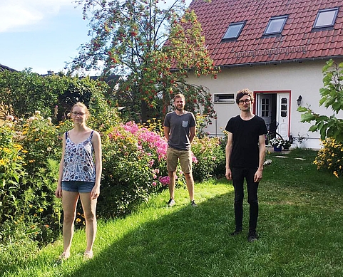 Das Bild zeigt die drei Mitglieder des JÖ-Vorstands Berlin-Brandenburg in einem Garten vor Bäumen und einem kleinen Haus.